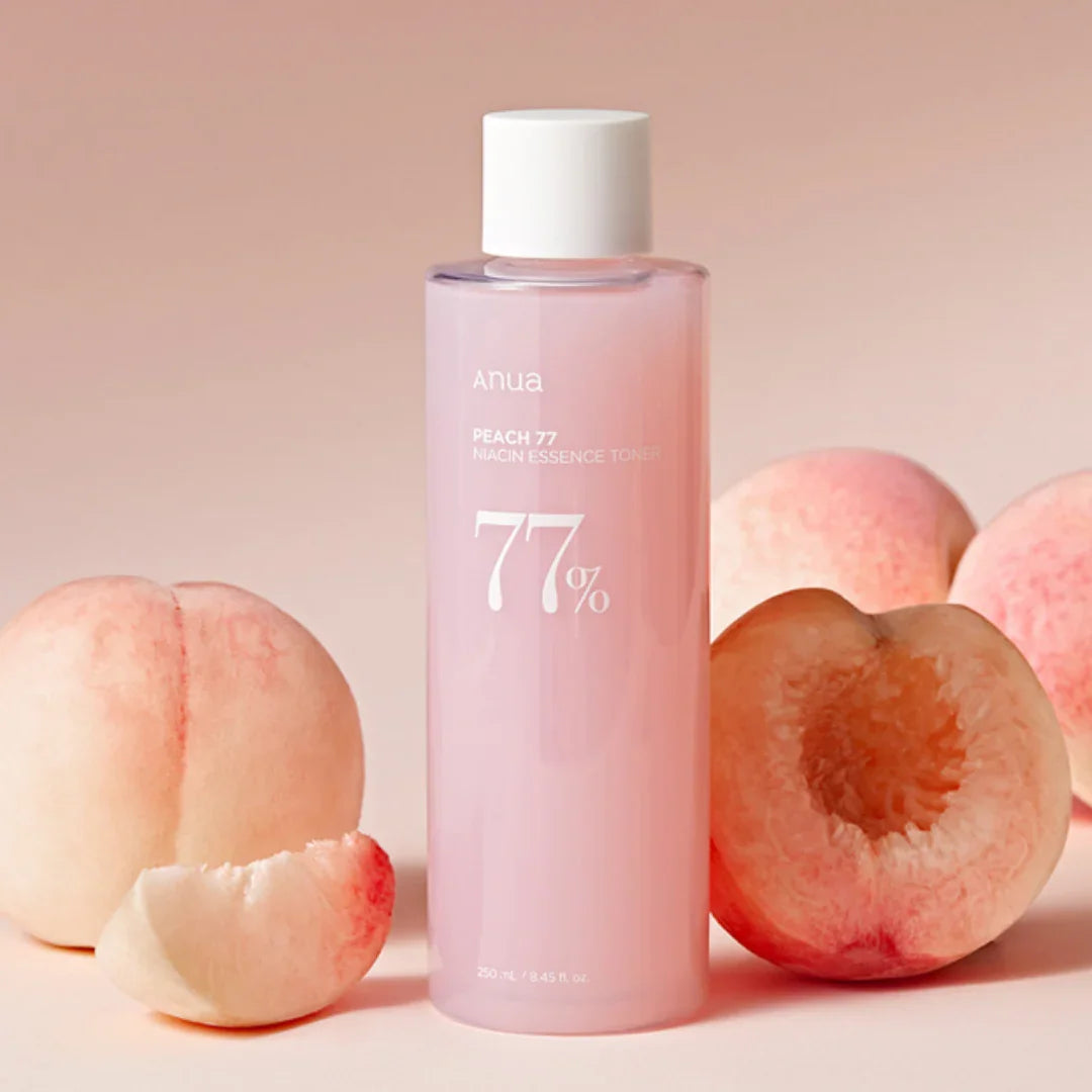 Anua Peach 77 Niacin Essence Toner 250ml bottle with fresh peaches on pink background, Korean skincare product